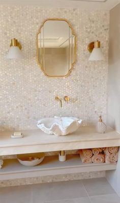 a bathroom with a sink, mirror and towels on the counter in front of it