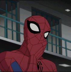 spider - man looking at the camera in front of a building