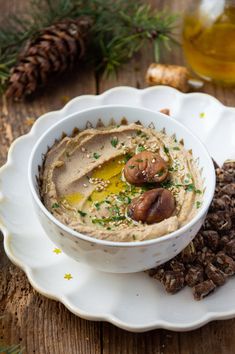 a white bowl filled with hummus and olives