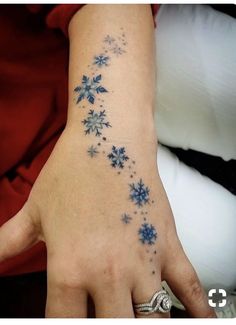 a woman's hand with blue snowflakes on it