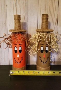 two pumpkins with faces painted on them are next to a measuring tape and some twine