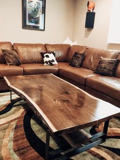 a living room with leather couches and a wooden coffee table in the center area