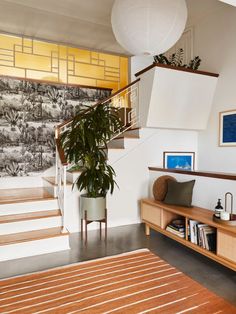 a living room with a plant and stairs