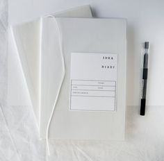 a notepad and pen sitting on top of a binder next to some papers