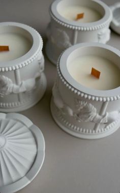 four white candles sitting on top of a table