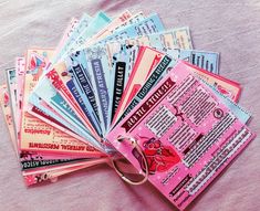 there are many different colored tickets on the pink sheet that is laying on top of each other