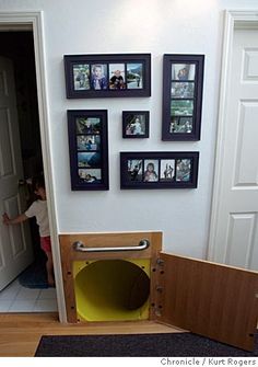 there is a dog house in the hallway with pictures on the wall and a door