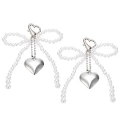 two heart shaped earrings with pearls hanging from them