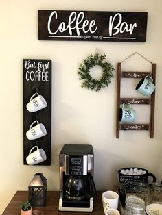 a coffee bar with cups and mugs on the counter next to a sign that says coffee bar