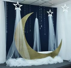 an image of a room decorated with white stars and moon decorations on the wall, along with sheer curtains