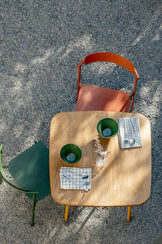 a wooden table with two green chairs next to it