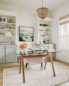 a glass table with flowers on it in the middle of a room