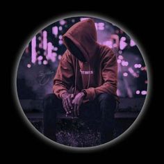 a man in a hoodie sitting on a bench with his hands clasped to his knees