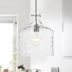 a clear glass light fixture hanging over a kitchen counter