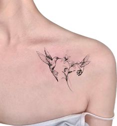 a woman's shoulder with two hummings and flowers on the back of her neck