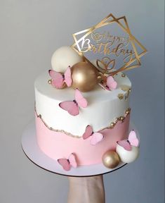 a birthday cake decorated with pink and gold butterflies