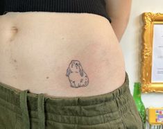 a woman's stomach with a small tattoo of a dog on the side of her belly