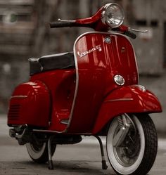 a red scooter is parked on the street