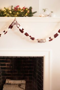 a fireplace decorated for christmas with lights and garland