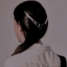 the back of a woman's head with a hair clip in her left hand