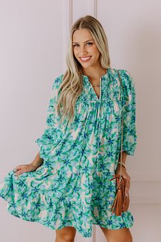 - Make memories one mimosa at a time in this darling dress! - Lightweight material with a floral print and a built-in skirt lining - A v-cut neckline with a tie - A smocked detail - Long, loose sleeves with elastic cuffs - A flowy silhouette that ends in A mini dress length hemline Chic Green V-neck Floral Dress, Flowy Green Summer Dress, Green Knee-length Dress For Brunch, Green Summer Dress For Brunch, Green V-neck Dress For Garden Party, Green Floral Print Summer Dress, Green Floral Print Mini Dress For Brunch, Green Floral Print V-neck Mini Dress, Green V-neck Floral Print Mini Dress