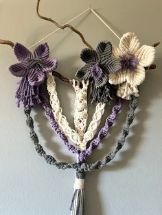 three crocheted flowers hanging on a wall