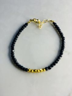 Black Bracelet. Stone Bracelet A part of the Semi Precious Stone Collection.  A simple and elegant handmade beaded bracelet made using Obsidian gemstones and gold plated beads.  Obsidian  Gold plated on Silver Round beads Adjustable clasp Please see my other listing for the matching necklace. Handmade Black Crystal Bracelet, Elegant Handmade Rondelle Beaded Bracelets, Elegant Handmade Black Beaded Bracelets, Elegant Black Beaded Bracelets Gift, Elegant Onyx Bracelets With Faceted Beads, Elegant Onyx Bracelet With Faceted Beads, Minimalist Black Beaded Bracelets With Faceted Beads, Black Bracelets With Faceted Round Beads, Gold Crystal Bracelet With Round Black Beads