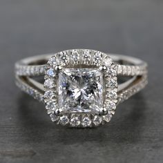 an engagement ring with a princess cut diamond surrounded by diamonds