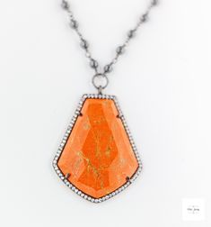 Stand out in this beautiful eye-catching burnt orange resin, hematite and cubic zirconia necklace. Bold and bright it is ready for your next event and bound to get you noticed! The beautiful uniquely shaped burnt orange resin bezel has shimmering ribbons of saffron yellow throughout and it is framed by sparkling cubic zirconia stones.Stunning, bright and shimmering faceted cherry burnt orange resin framed by black gold-plated sterling silver bezel that is studded with sparkling cubic zirconia. Black gold-plated short and long oval link chain. Beautiful shimmering silvery black hematite beads wrapped in black gold-plated chain. Gunmetal-plated brass lobster clasp for a secure and comfortable fit. 18.5 inches long. Only one available! Make this gorgeous limited edition necklace yours today! Bohemian Orange Gemstone Necklaces, Artisan Orange Gemstone Necklace, Unique Hand-strung Amber Necklace, Orange Gemstone Pendant Jewelry, Coral Jewelry Vintage, Luxury Orange Agate Necklace, Original Necklace, Orange Necklace, Hematite Necklace