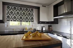 a cutting board with lemons on top of it in a kitchen next to a window