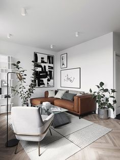 a living room filled with furniture and plants on top of a hard wood floored floor