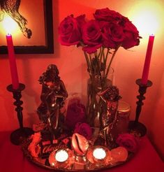 candles and roses in a vase on a table