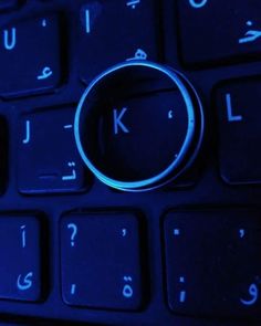 a close up of a computer keyboard with a ring on it's middle key