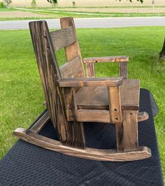 a wooden rocking chair sitting on top of a black blanket