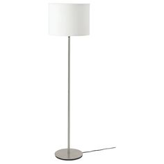 a floor lamp with a white shade on the base and a light bulb plugged in