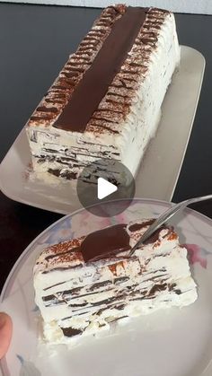 someone is cutting into a cake with chocolate and cream frosting on the top slice