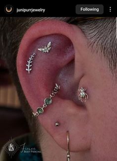 a man wearing ear piercings on his left side with an insect and leaf design