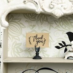 a white shelf with two black and white figurines on it's sides