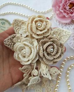 crocheted flowers are being held by a hand