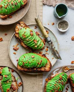 two plates with toast covered in green frosting and topped with slices of bread next to a knife