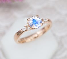 a close up of a ring with a blue and white stone in it on a table