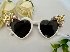 ❤️Beautiful embellished heart statement sunglasses. ❤️These classic yet elegant sunglasses are the perfect accessory for shading you from the sun while still look stylish. ❤️The oversized plastic frames have tinted black lenses. On either side of the frames they have a mixture iridescent small flowers, jewels and crystals. ❤️These would be great as a wedding accessory, holidays, special occasions or everyday wear. ✨All glasses come in a black pouch to keep them safe, please also handle with care as they are handmade.  ✨Lots more different styles of sunglasses available in the shop:  https://www.etsy.com/uk/shop/AlexisExclusive?ref=s2-header-shopname ✨To be kept up to date with new designs please FAVORITE MY SHOP ✨All Alexis Exclusive designs, design concepts, and items are Copyright ©2022 Elegant Heart-shaped Sunglasses With Tinted Lenses, Elegant Heart-shaped Tinted Sunglasses, Chic Heart-shaped Sunglasses For Summer, White Heart-shaped Sunglasses With Gradient Lenses, White Heart-shaped Sunglasses With Tinted Lenses, Heart-shaped White Sunglasses With Tinted Lenses, White Heart-shaped Sunglasses For Summer, Elegant Heart-shaped Party Sunglasses, Elegant Sunglasses