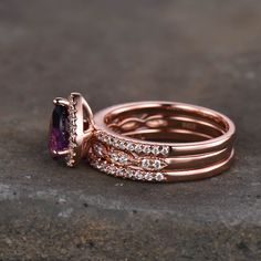 two rose gold wedding rings with an amethorate and diamond set on top