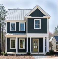 a black and white two story house with lots of windows