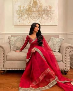 a woman in a red dress sitting on a couch