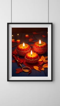 three lit candles sitting on top of a table with autumn leaves around them and scissors