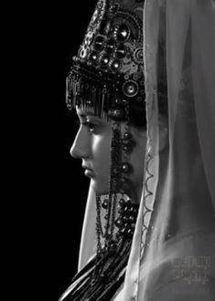 black and white photograph of two women wearing headdress, veils and jewelry