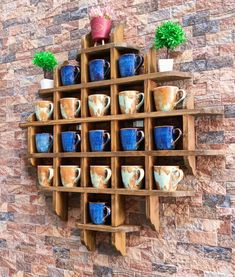 a wooden shelf with cups on it against a brick wall in the shape of a heart