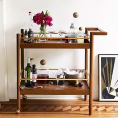 a bar cart with bottles and glasses on it