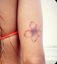 a woman's arm with a flower tattoo on it